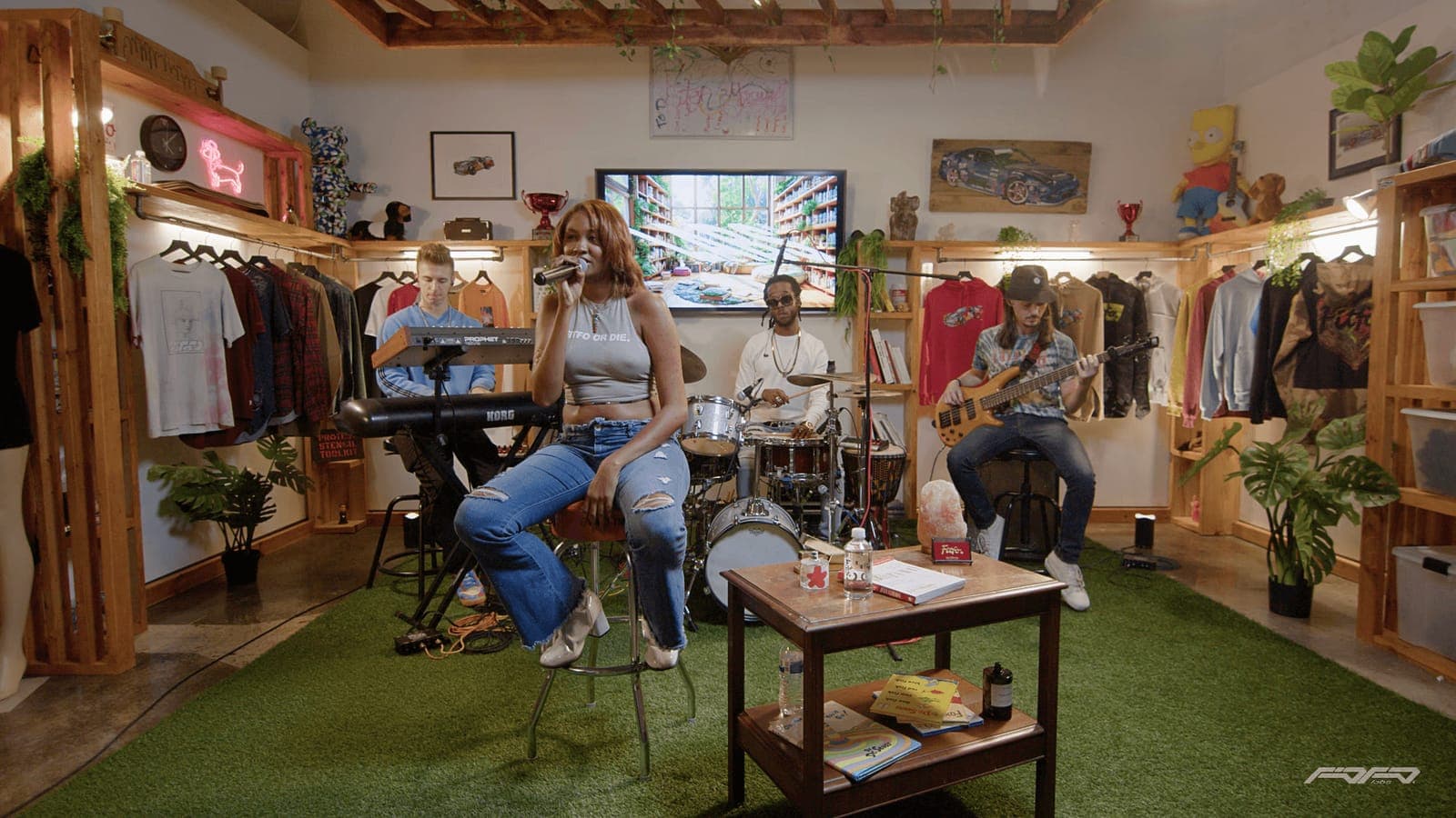 A band plays to a seated audience in a room lined with clothing racks, a Lab Session concert