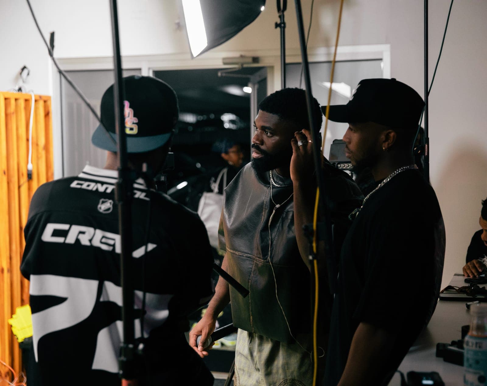 A crew and artists gather under studio lights during a video shoot