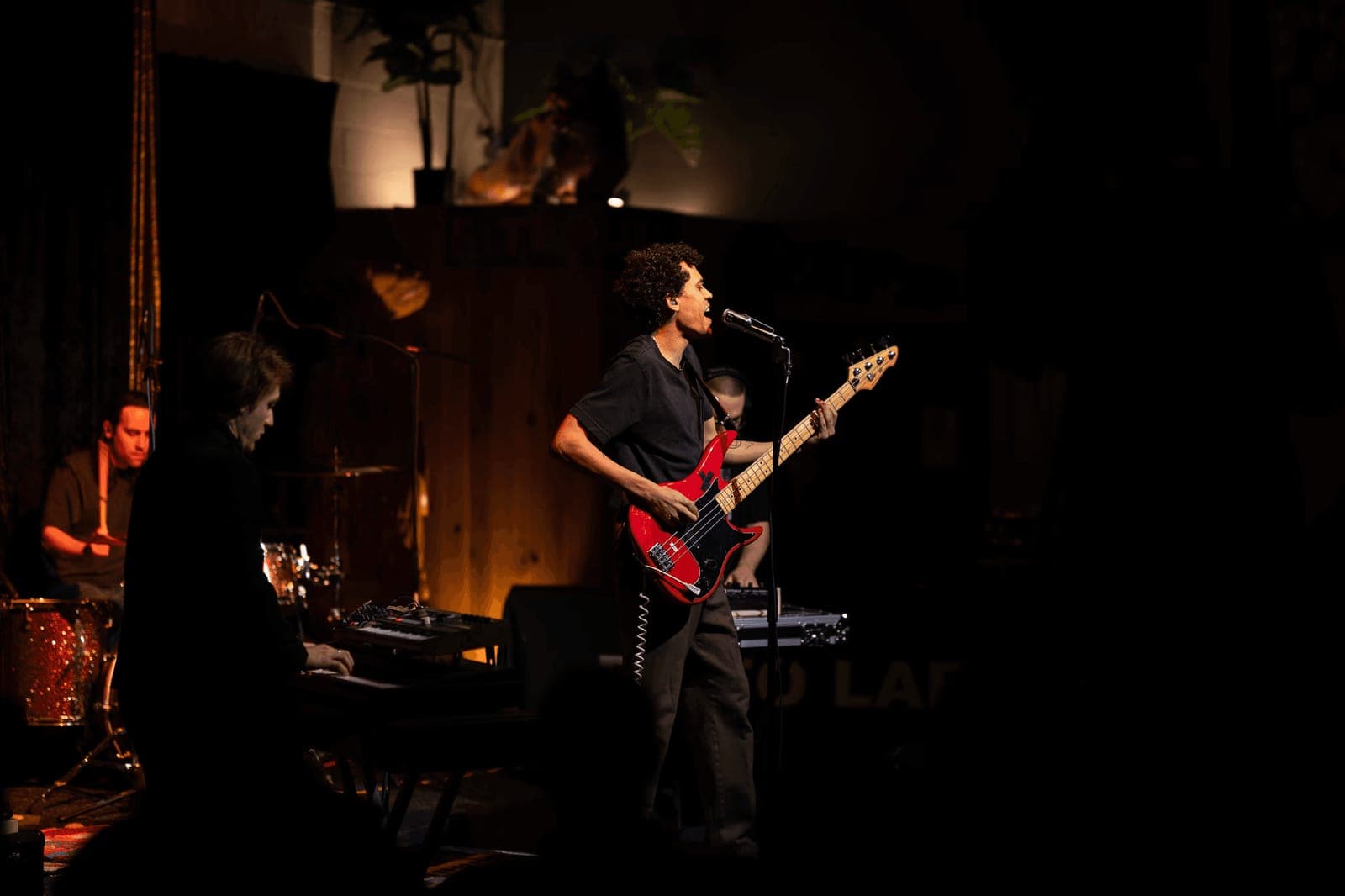 A band performs on a dark stage under warm lights