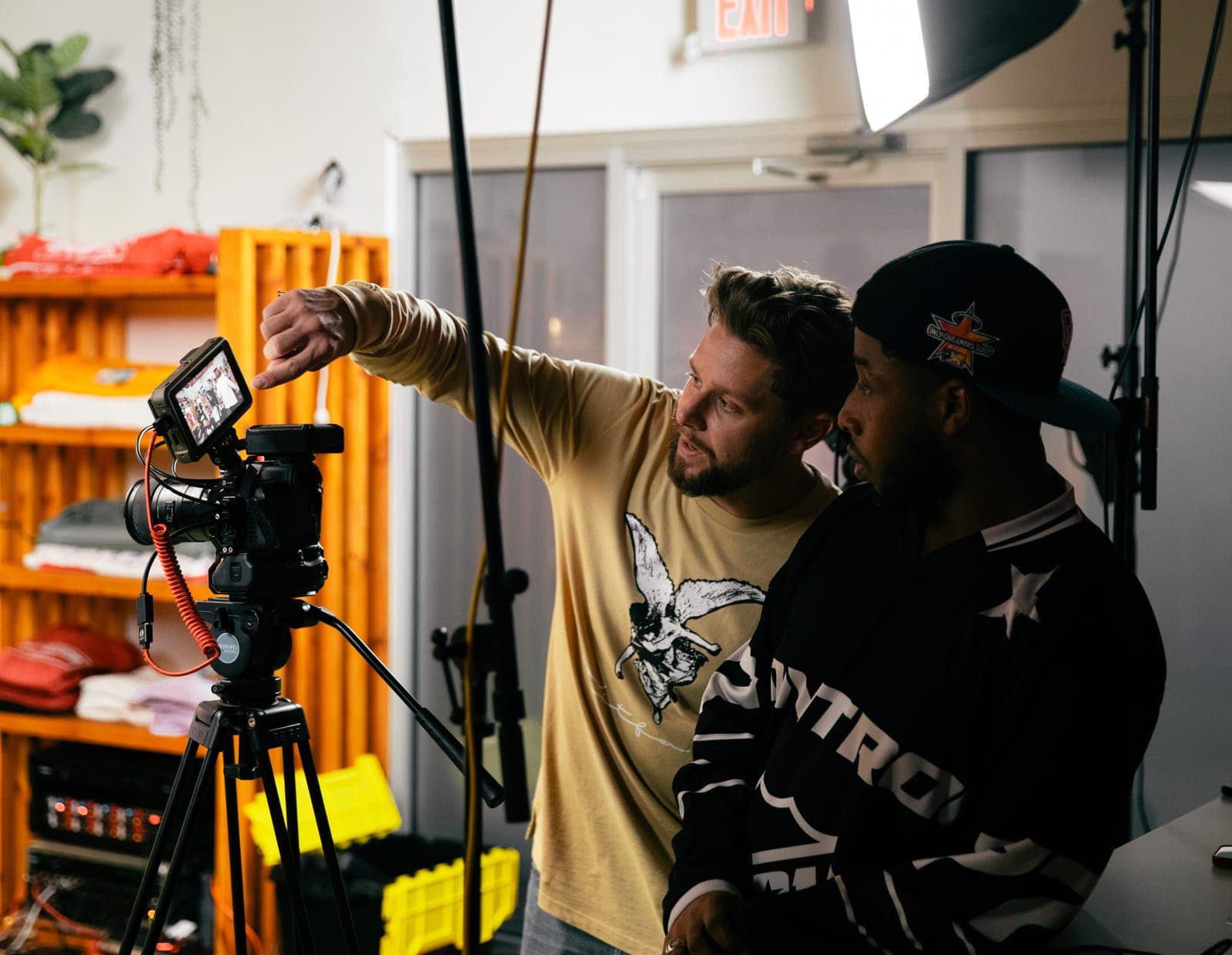 A crew sets up a camera on a tripod in the studio