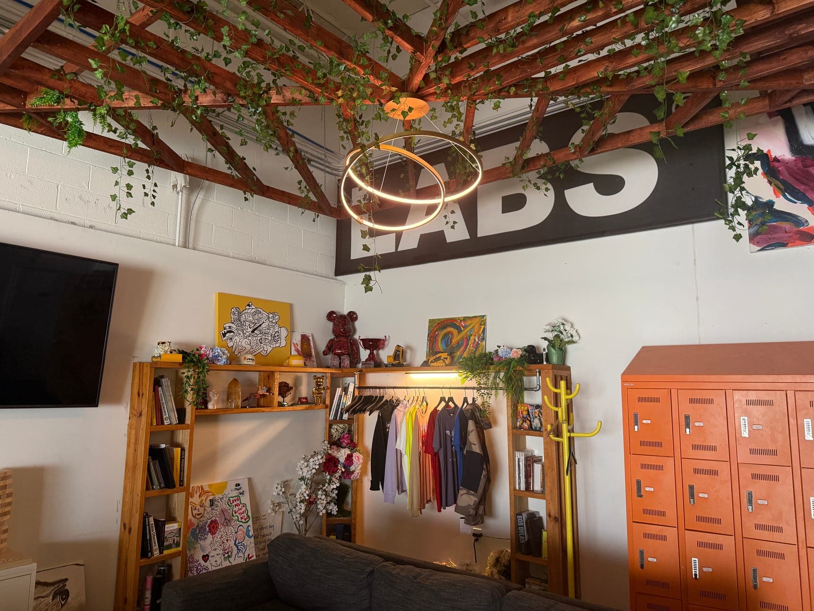 The Fitfo Labs lounge in Atlanta: vines over the beams, a ring light under the LABS sign, a clothing rack and orange lockers